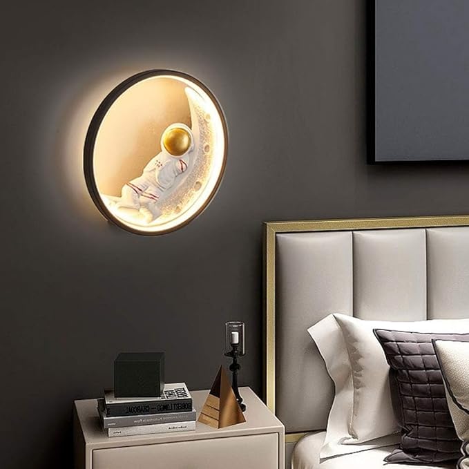 Round wall light fixture on a dark wall above a bed with a nightstand.