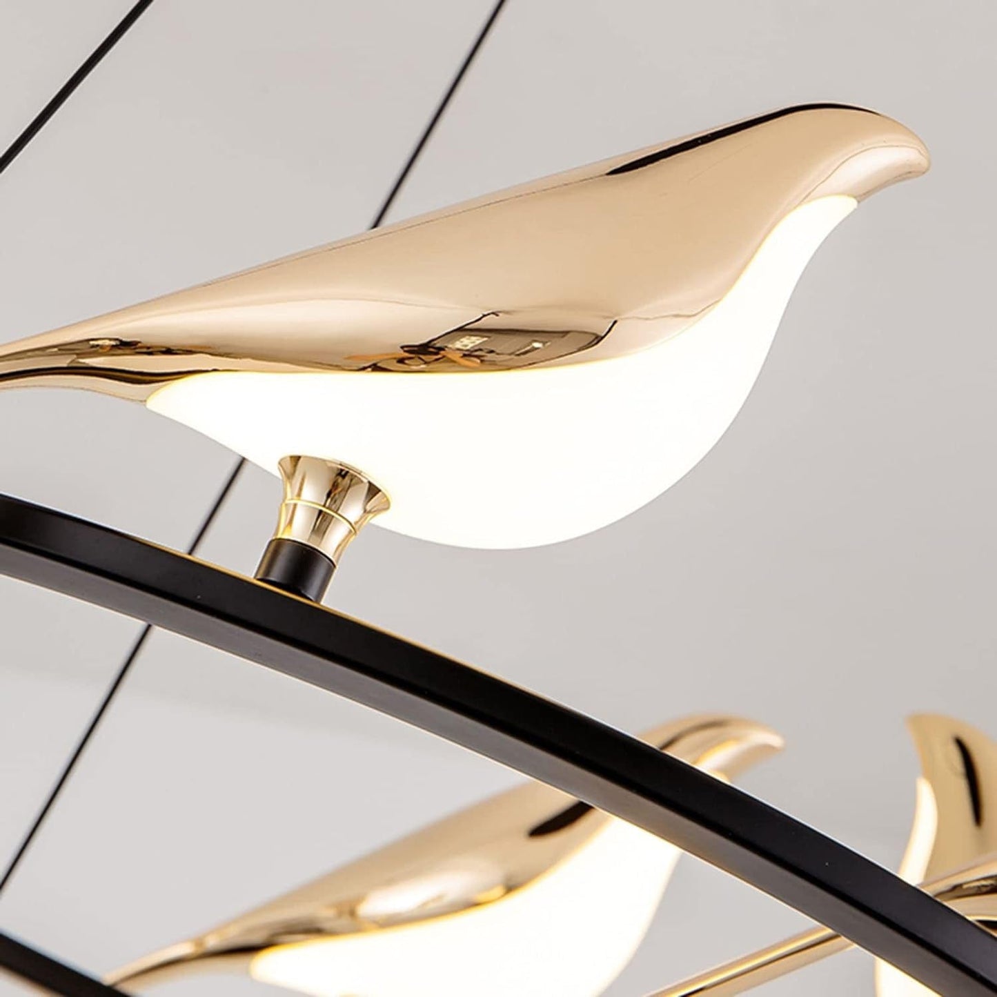 Modern ceiling light fixture with gold bird-shaped lamps on a white background
