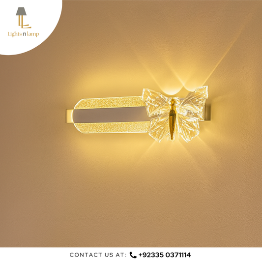 Decorative wall light fixture with butterfly design on a beige wall, branded 'Lights n Lamp'.
