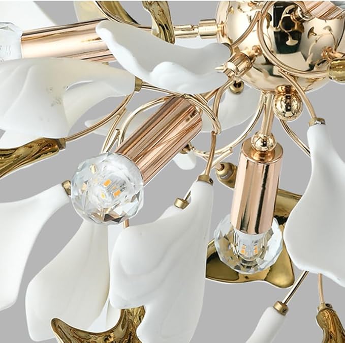 Close-up of a chandelier with white ceramic shades and gold metal accents.