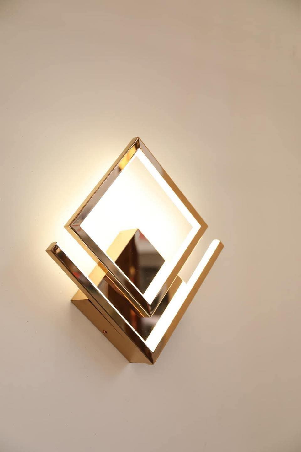 Modern wall light fixture with gold frame on a neutral background