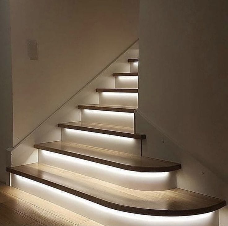 Wooden staircase with embedded lighting on a white wall.