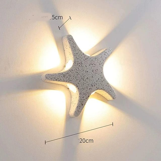 Star-shaped wall light fixture on a white wall with measurements indicated.
