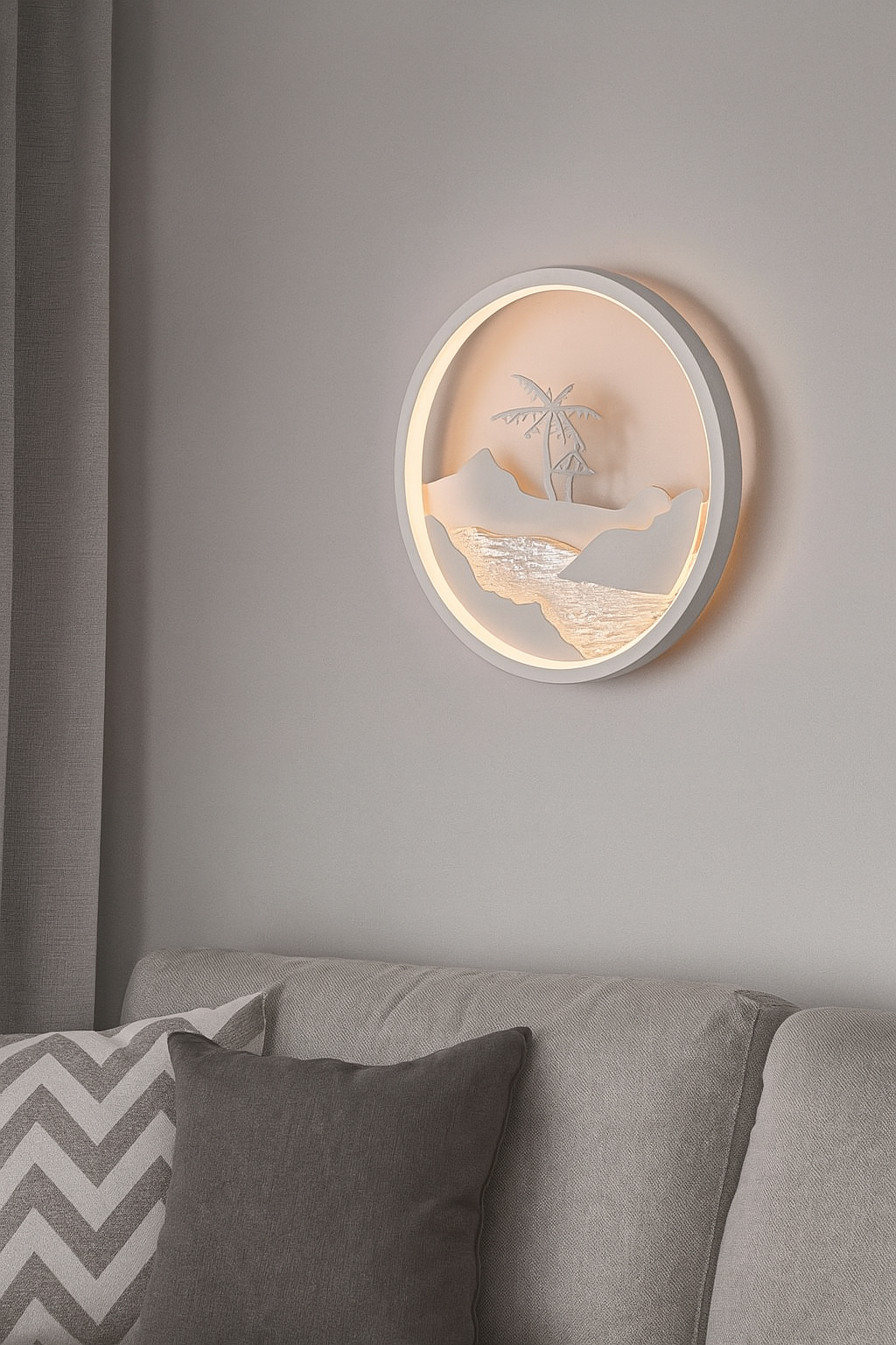 Round wall light fixture with scenic design on a gray wall above a sofa.