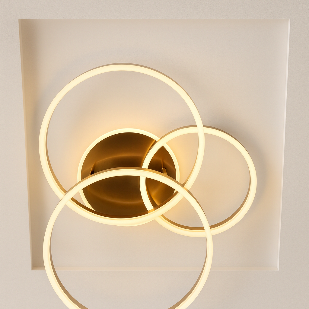 Modern wall light fixture with three gold rings on a neutral background