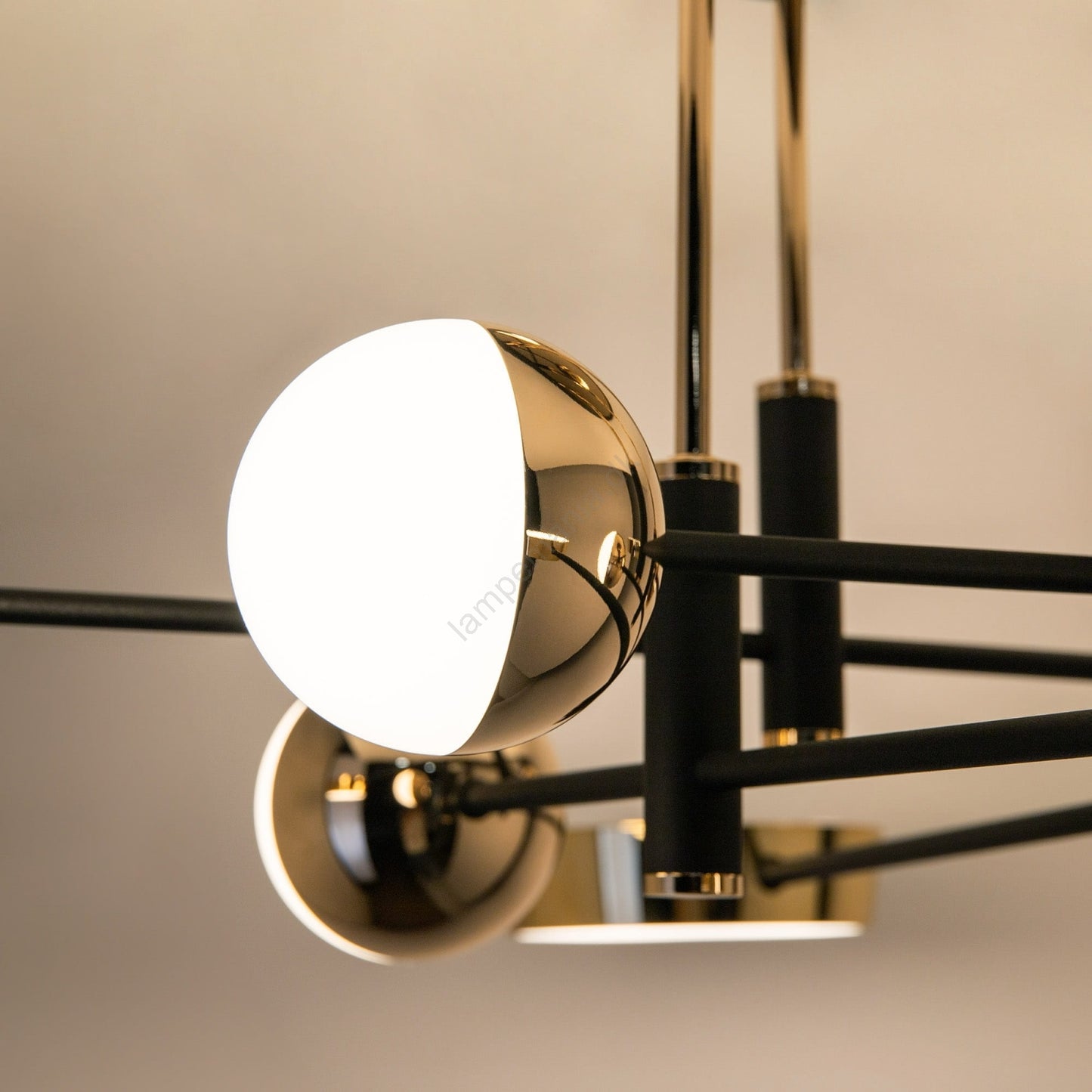Modern ceiling light fixture with gold and black design on a neutral background