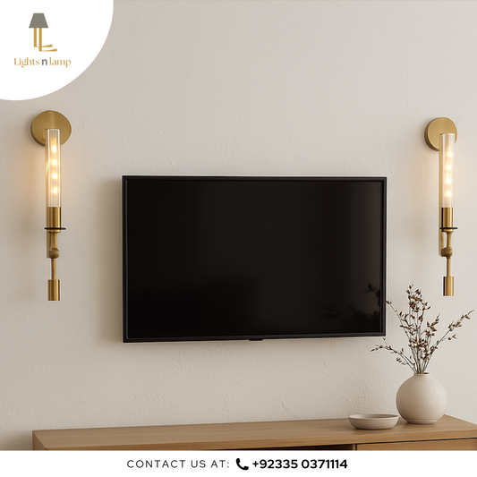 Modern living room setup with a TV mounted on the wall, flanked by two gold sconces.