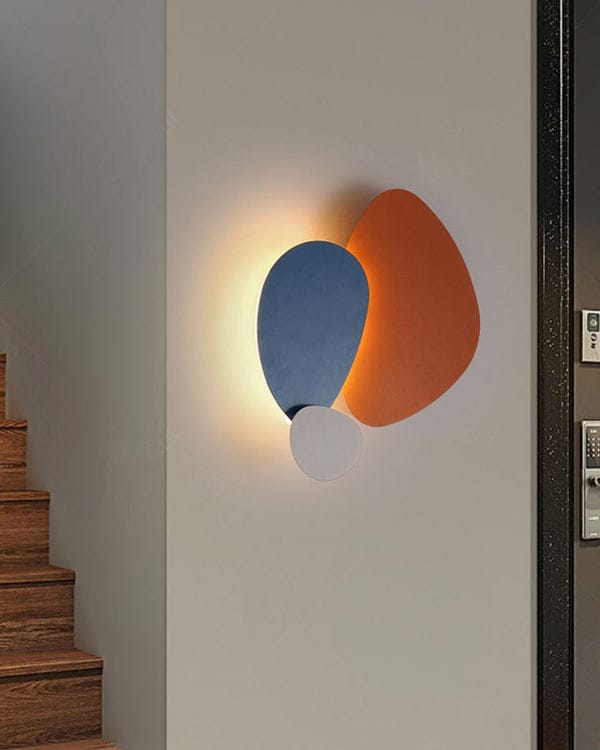 Modern wall lamp with blue and orange design on a neutral wall.