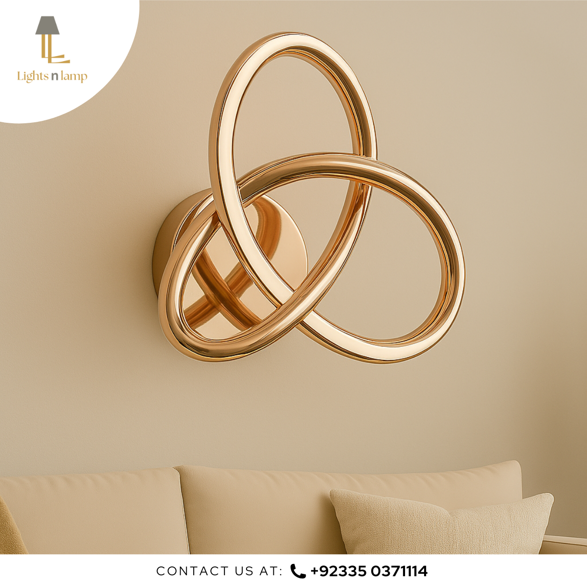Gold wall sconce with interlocking rings on a beige wall