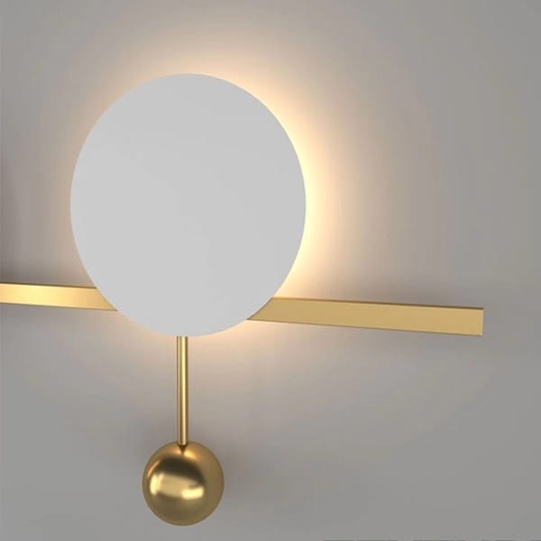Modern wall lamp with white spherical shade and gold arm on a neutral background