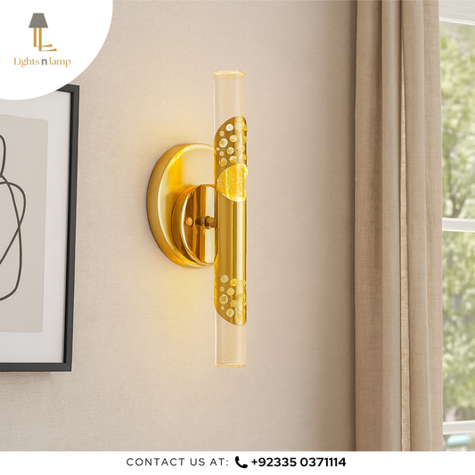 Gold wall sconce with glass shade on a beige wall, next to a window with curtains.