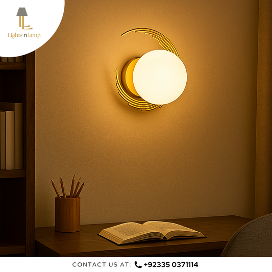 Wall-mounted light fixture casting a warm glow on a desk with an open book and pen holder.