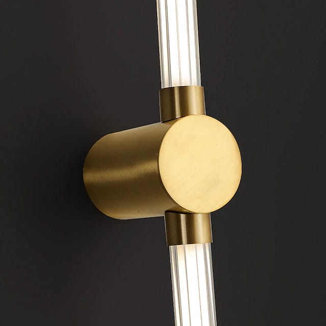 Modern wall light fixture with gold and clear design on a black background
