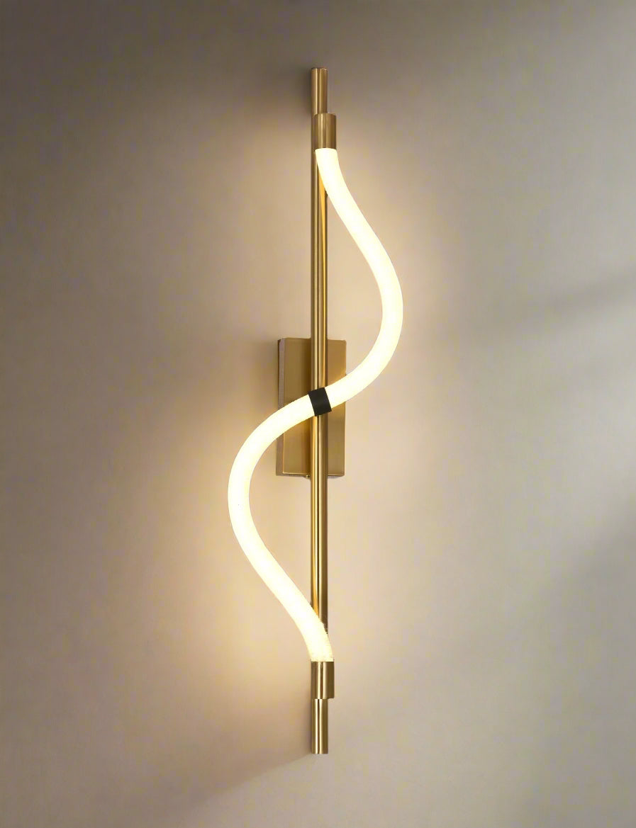 Modern wall light fixture with gold finish and curved design on a gray background