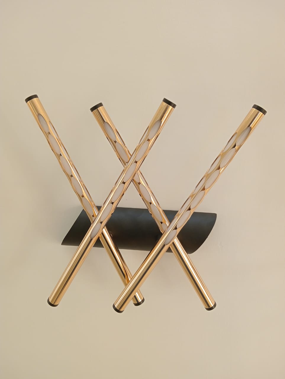 Wooden folding stool with black seat on a beige background