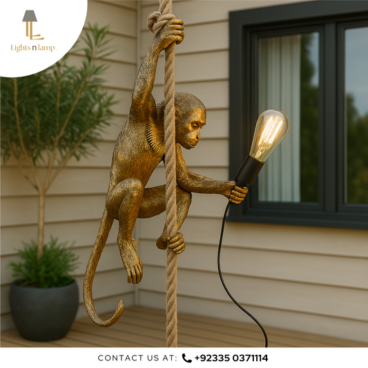 Gold monkey lamp holding a light bulb against a house exterior background