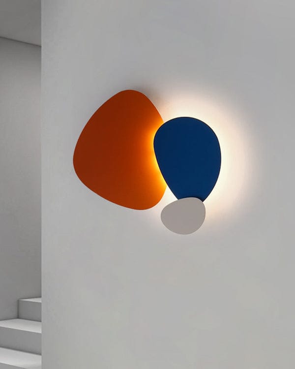 Modern wall light fixture with orange, blue, and white components on a neutral background