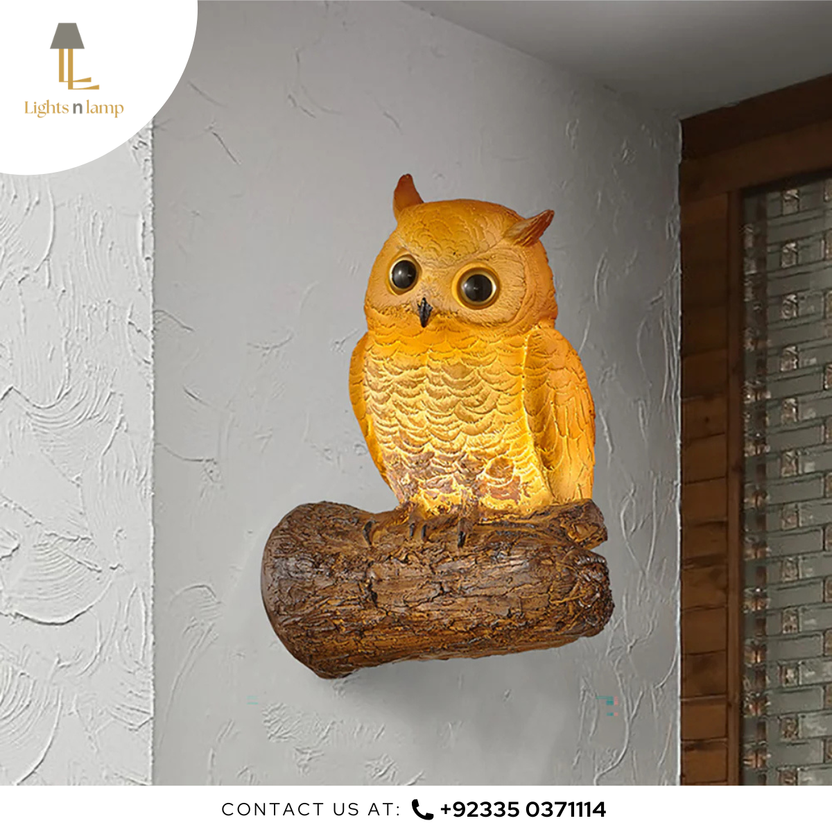 Owl-shaped wall light fixture on a white wall with contact information at the bottom.