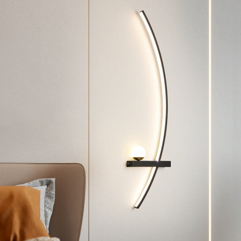 Modern wall lamp with curved design on a neutral wall