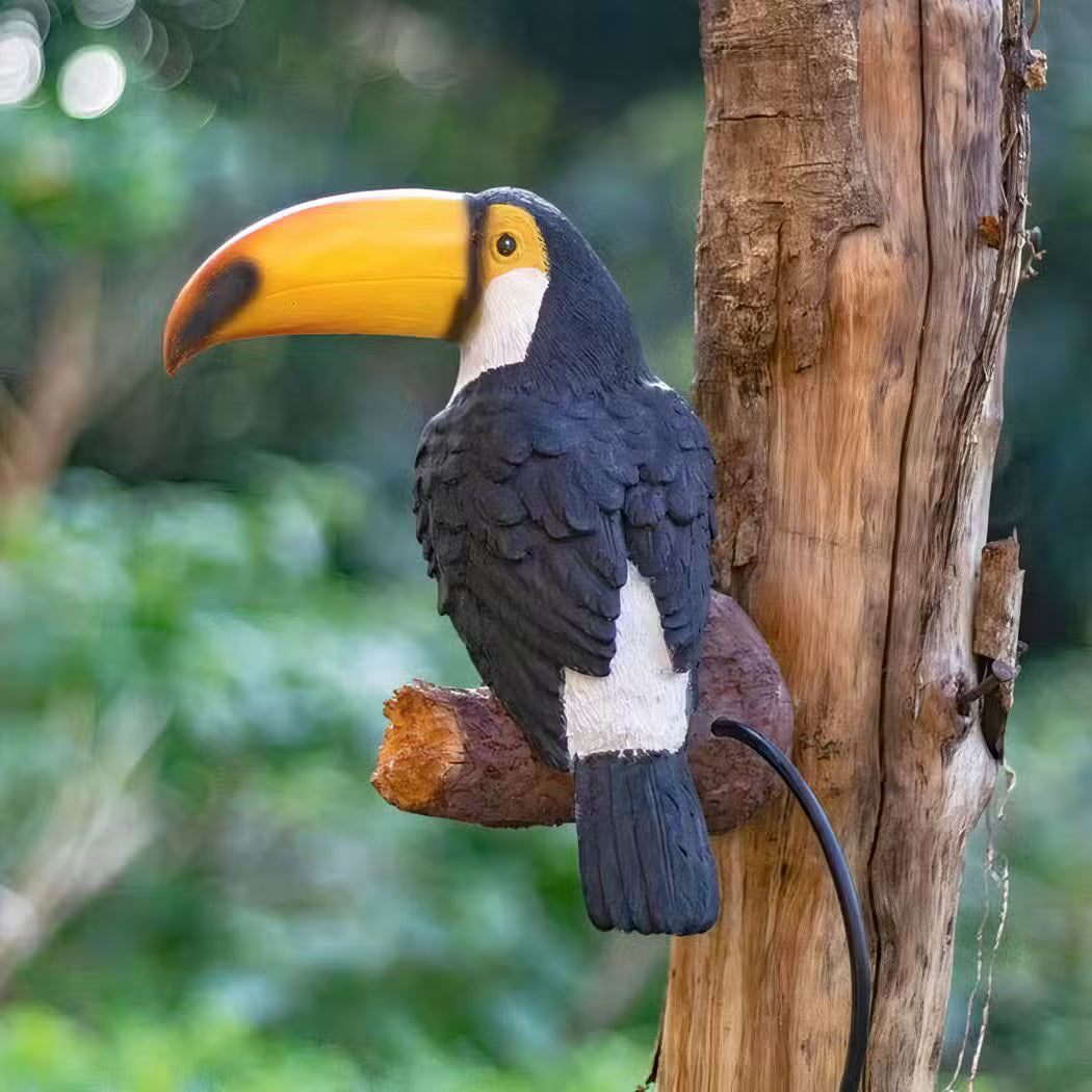 Decorative toucan bird perched on a branch with a natural background