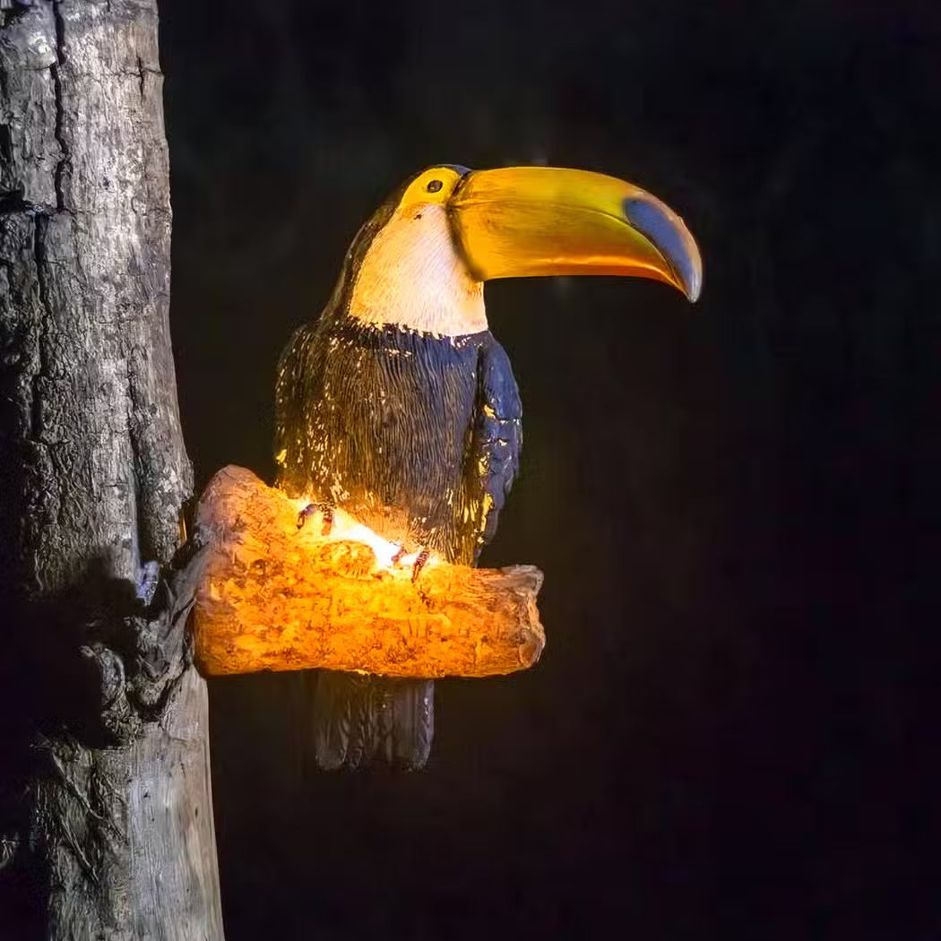 Toucan perched on a branch with a dark background